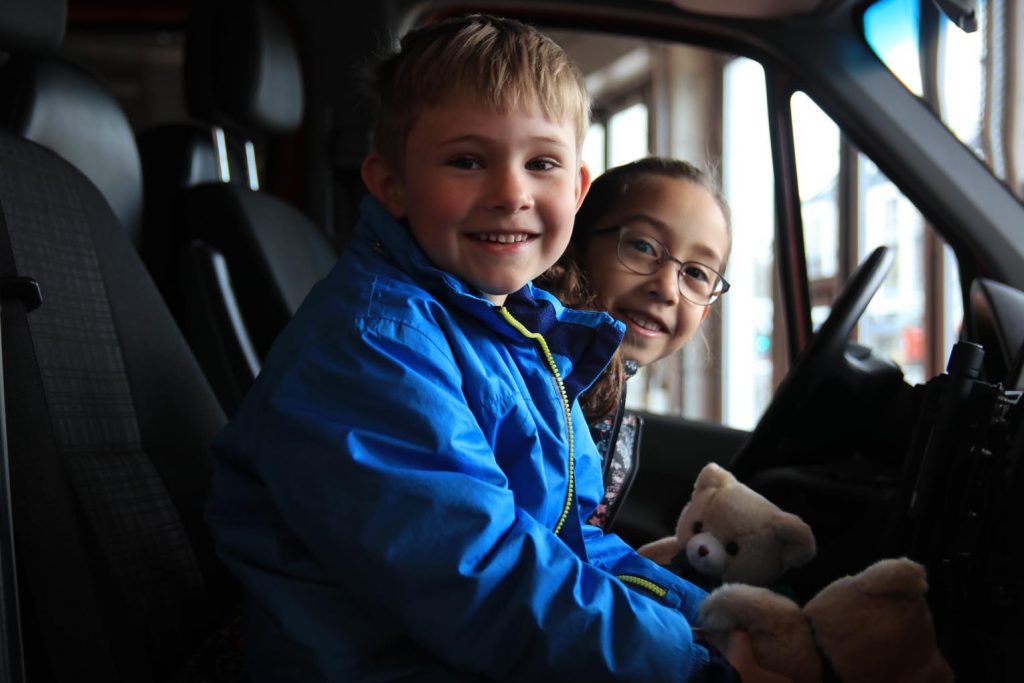 Henry und Amalia nehmen gleich mal auf dem Beifahrersitz des Feuerwehrwagens Platz.