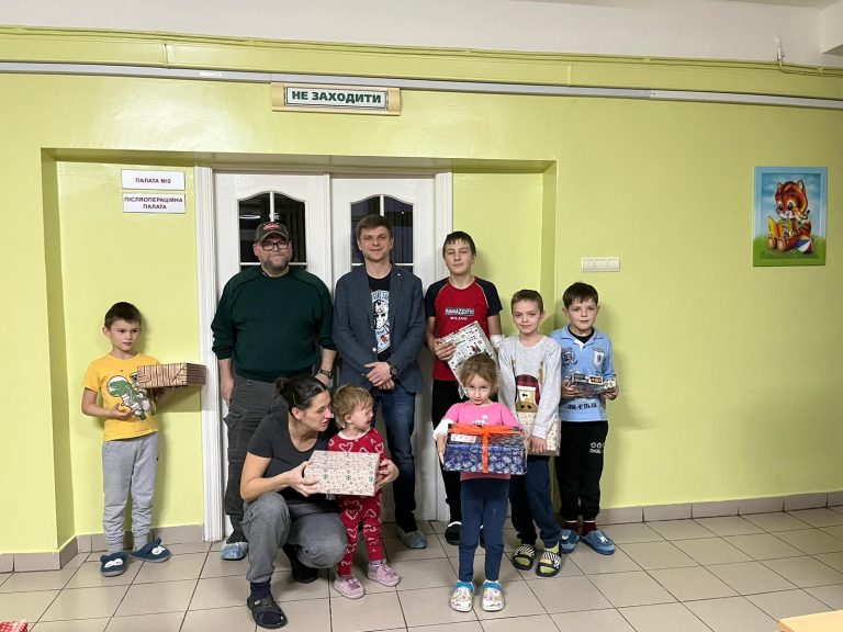 Michael Post (2. v. l. stehend) erreicht rechtzeitig an Heiligabend 2022 das Kinderkrankenhaus Tschernihiv, um die Geschenke der Schüler:innen der Grundschulen Kriftel und Mammolshain zu übergeben.